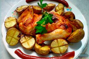 Pollo con patate al forno e salsa di pomodoro su un piatto