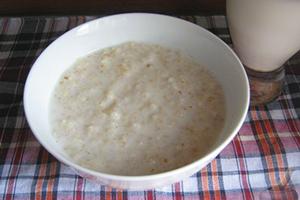 Munga il porridge in un piatto bianco e su una tovaglia a quadretti