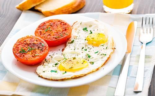 Пържени яйца с домати в чиния