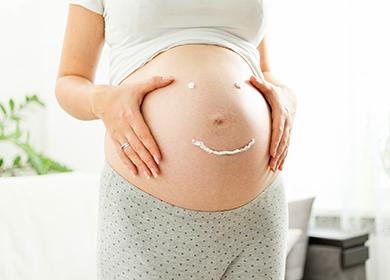 Emoticon cremoso su una pancia incinta