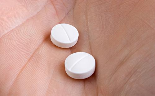 Weiße Pillen in Händen