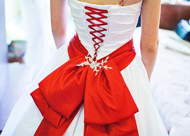Червен лък върху бяла рокля