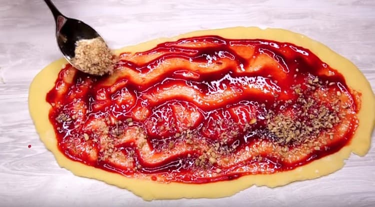 Eine Schicht Marmelade mit gehackten Nüssen bestreuen.