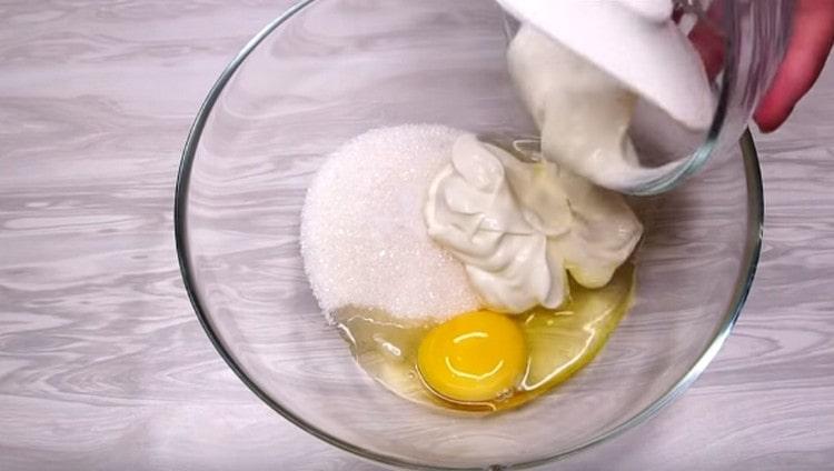 Verbinden Sie in einer anderen Schüssel das Ei. saure Sahne, Zucker und Salz.