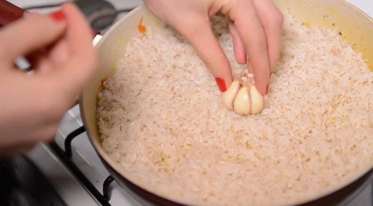 Nel riso al centro della padella mettiamo una testa d'aglio.