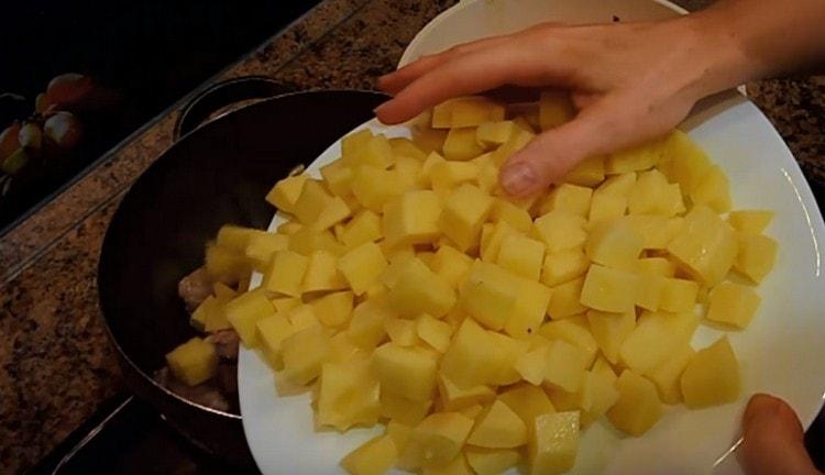 Taglia le patate a dadini e distribuiscile immediatamente sulla carne.