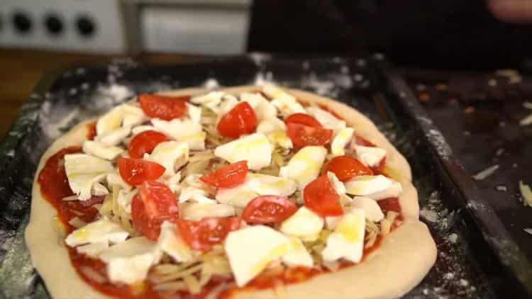 Per fare una pizza classica, metti il ​​ripieno sull'impasto