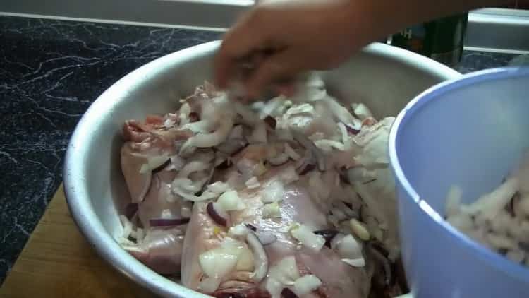 За да приготвите заешката марината във фурната, смесете месото с лука