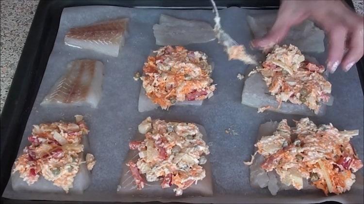 Per cuocere il pesce sotto una pelliccia nel forno, metti il ​​ripieno sul pesce