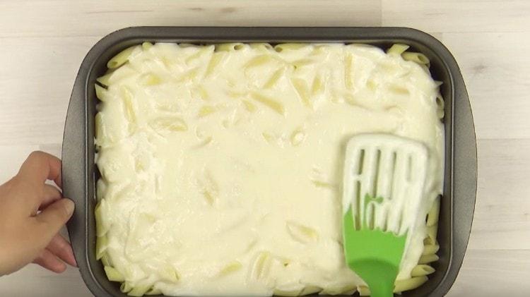 Copri la pasta con mezza salsa besciamella.