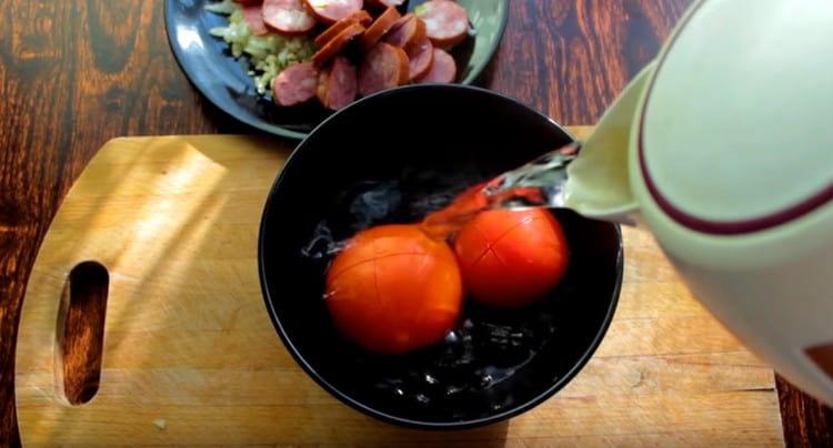Gießen Sie kochendes Wasser über die Tomaten und schneiden Sie sie kreuzweise ein.