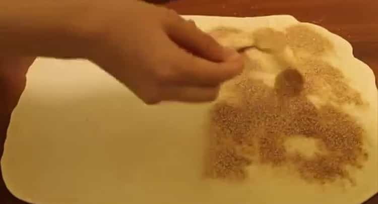 Per preparare i panini, metti lo zucchero sull'impasto
