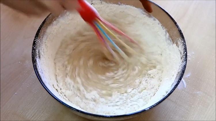 Um einen Cupcake in Milch zu machen, sieben Sie das Mehl