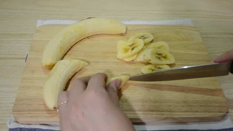 Per preparare un muffin alla banana e cioccolato, taglia una banana