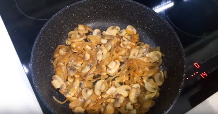 Fügen Sie Pilze der Zwiebel hinzu und braten Sie bis zart.