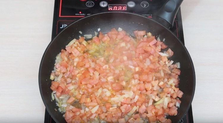 Aggiungi i pomodori alla cipolla, friggi fino a renderli morbidi.