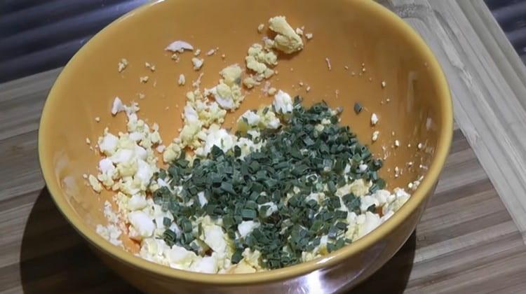 Facciamo bollire le uova sode, mescoliamo con cipolle verdi tritate.