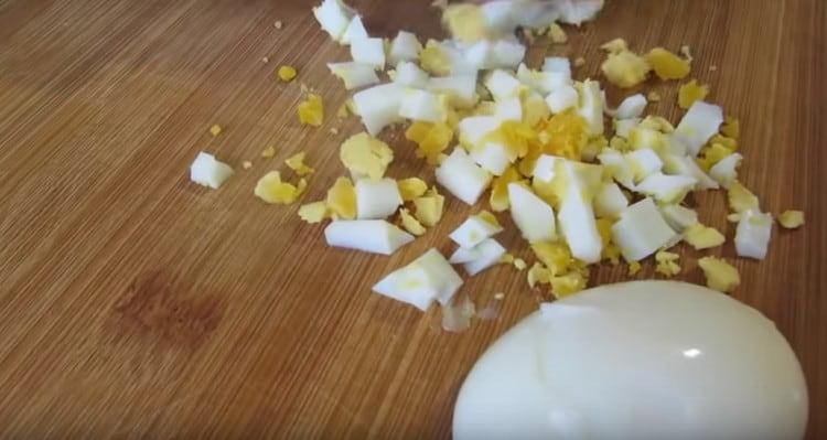 също като сиренето, нарязваме варени яйца.