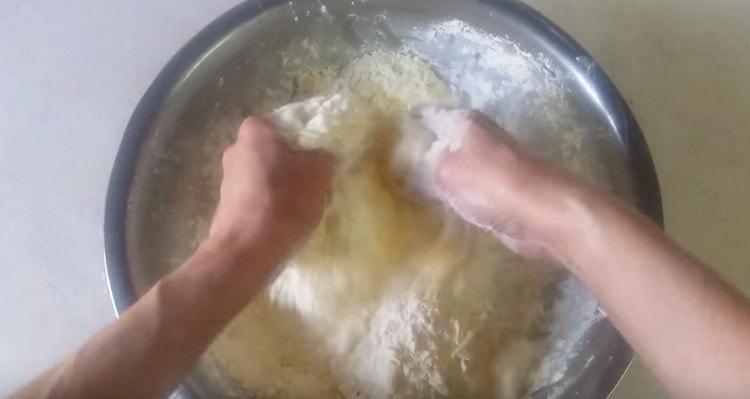 Hände reiben die Butter und Mehl in Krümel.