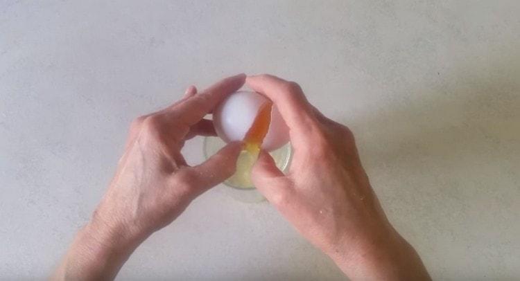 Ein Ei in ein Glas zerbrechen.