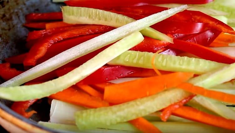 Разстелете нарязаните зеленчуци в тигана.