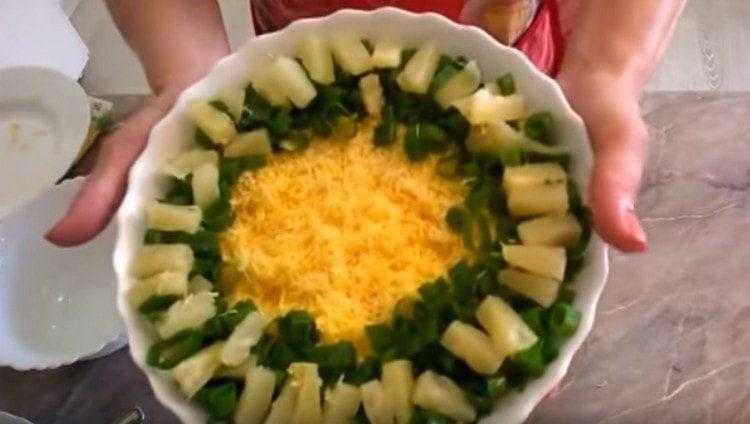 Decorare l'insalata con bastoncini di granchio e ananas con erbe fresche.