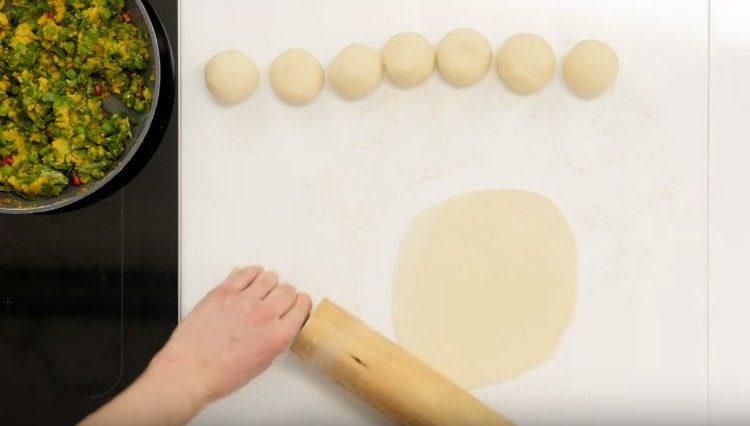 Stendi una palla da ogni pezzo di pasta, quindi stendila con un mattarello.